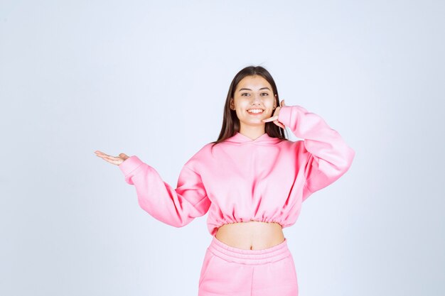 Girl in pink pajamas making call sign