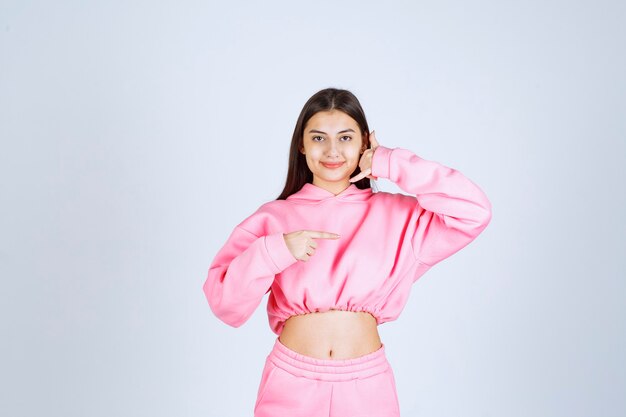 Girl in pink pajamas making call sign