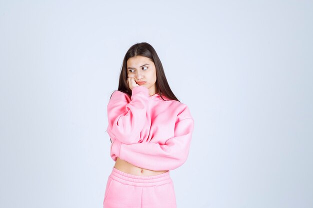 Girl in pink pajamas making very agressive and angry face