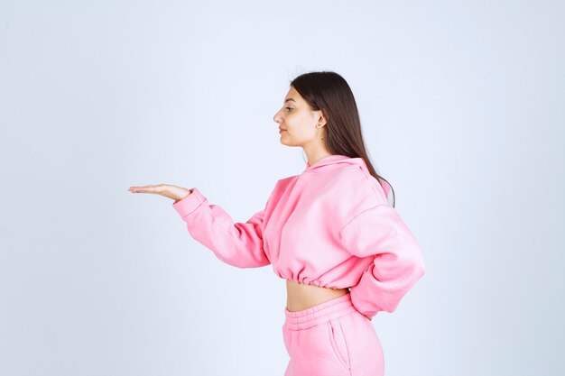 Girl in pink pajamas pointing at something on the left