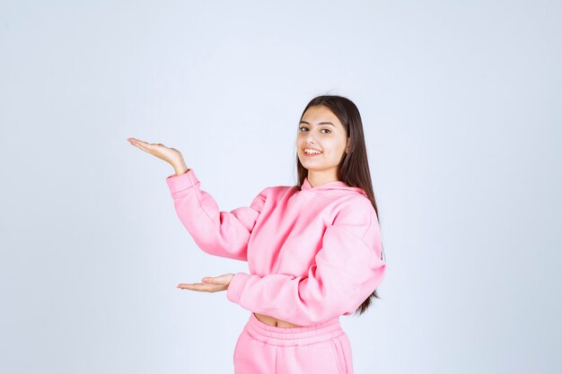 Girl in pink pajamas pointing at something on the left