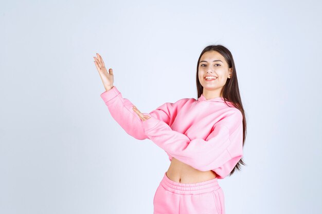 Girl in pink pajamas pointing up