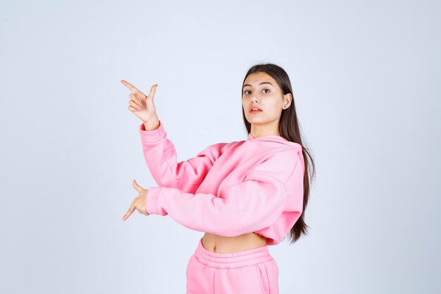Девушка в розовой пижаме, указывая вверх