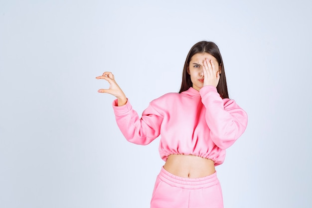 Girl in pink pajamas showing the amount of a product