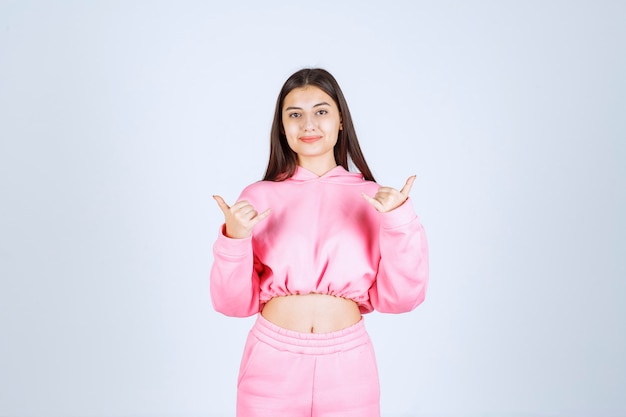 Girl in pink pajamas showing thumb up