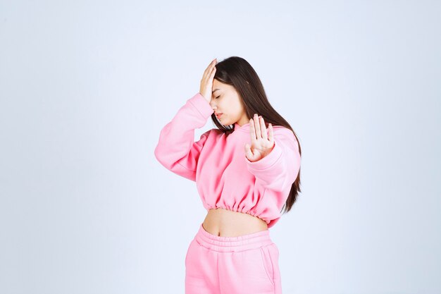 Girl in pink pajamas stopping something or somebody