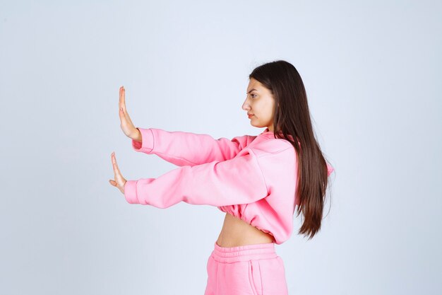 Free photo girl in pink pajamas stopping something or somebody