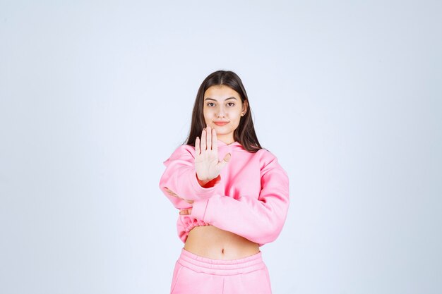 Girl in pink pajamas stopping something