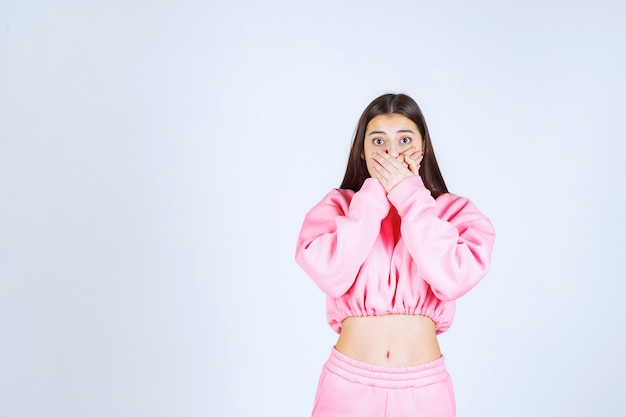 Девушка в розовой пижаме удивлена и шокирована