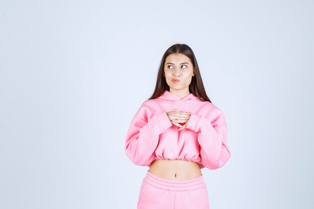 Girl in pink pajamas thinking and analizing