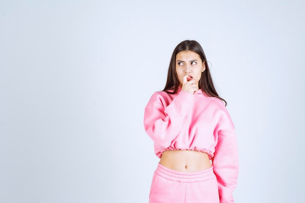 Girl in pink pajamas thinking and analizing