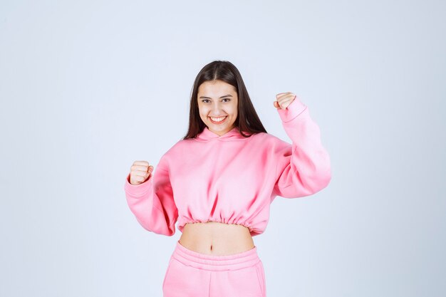 Girl in pink pijamas is a winner and showing her fists