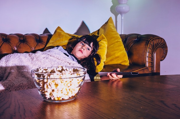 Girl under plaid watching TV