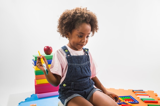 Free photo girl on play mat with paint brush in studio