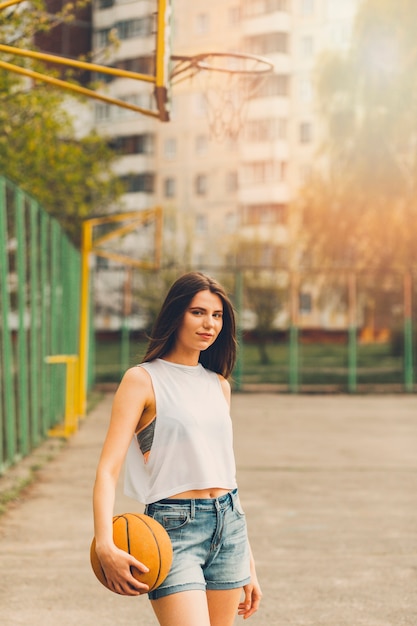 Foto gratuita ragazza che gioca a basket in ambiente urbano