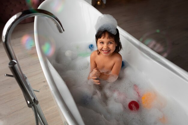 Girl playing in bathtub high angle