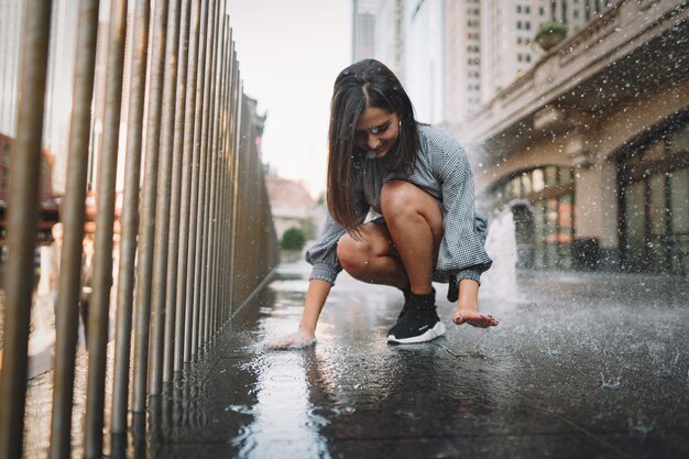 девушка играет и танцует на мокрой улице