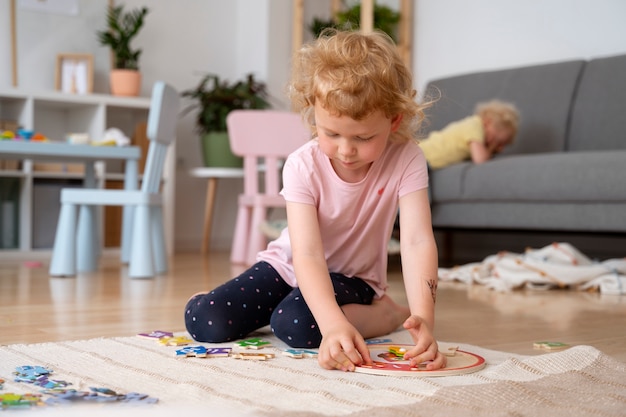 Girl playing on floor with puzzle front view