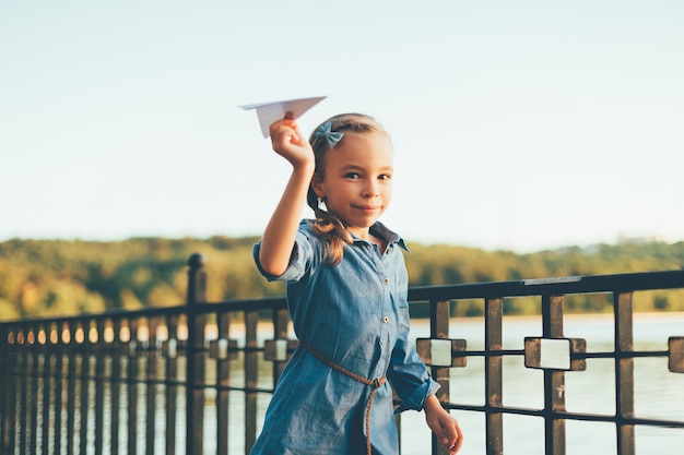 Free photo girl playing, running with toy paper airplane