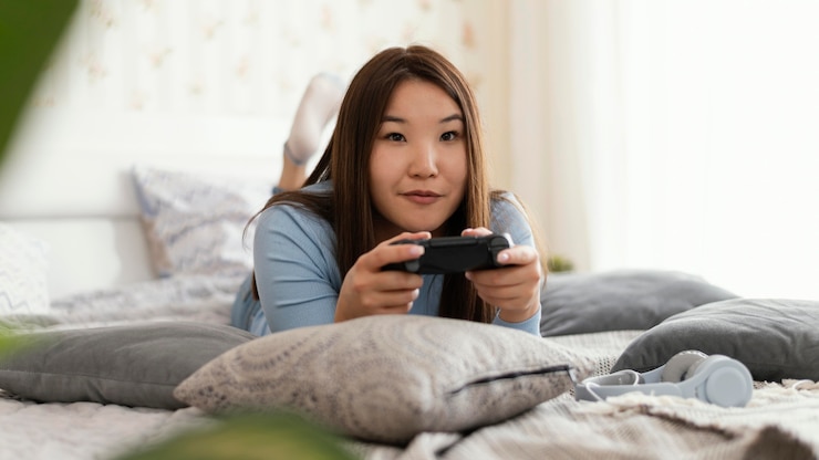 무료 Photo 침대에서 비디오 게임을하는 소녀