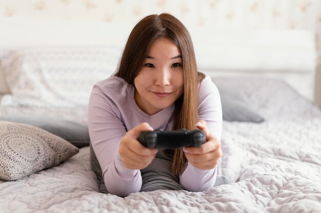 Girl playing videogames at home full shot