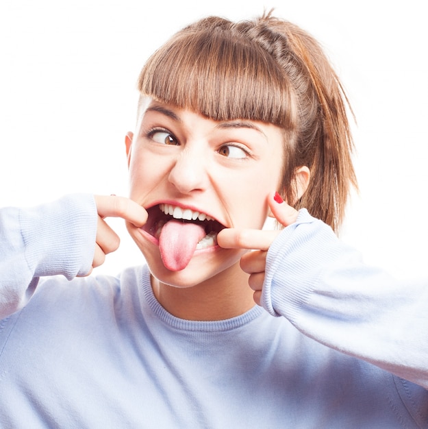 Girl playing with her eyes and showing the tongue