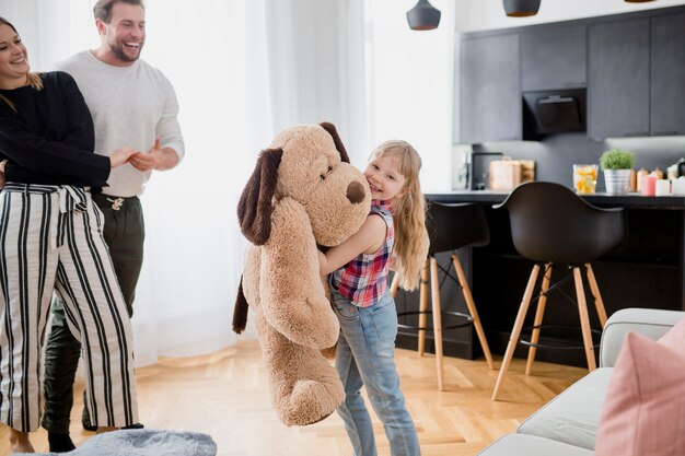 Girl playing with plush toy near parents