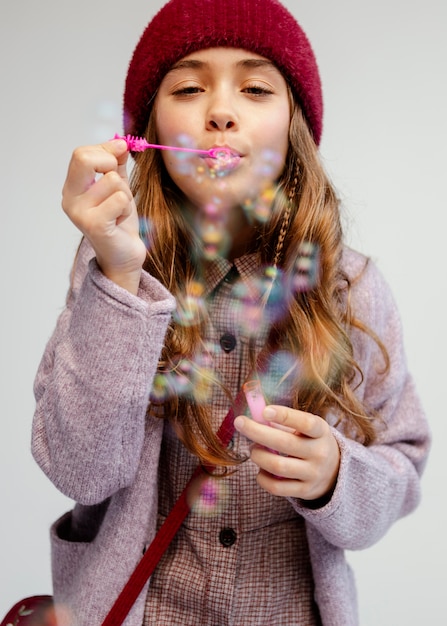 Foto gratuita ragazza che gioca con le bolle di sapone