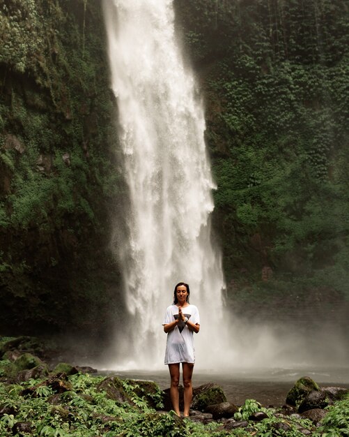 Girl posing against the backdrop of a waterfall