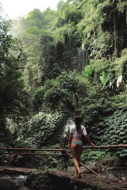 Free photo girl posing against the backdrop of a waterfall