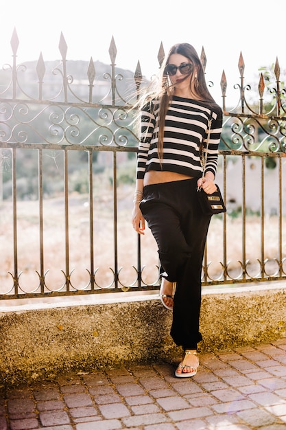 Free photo girl posing by fence