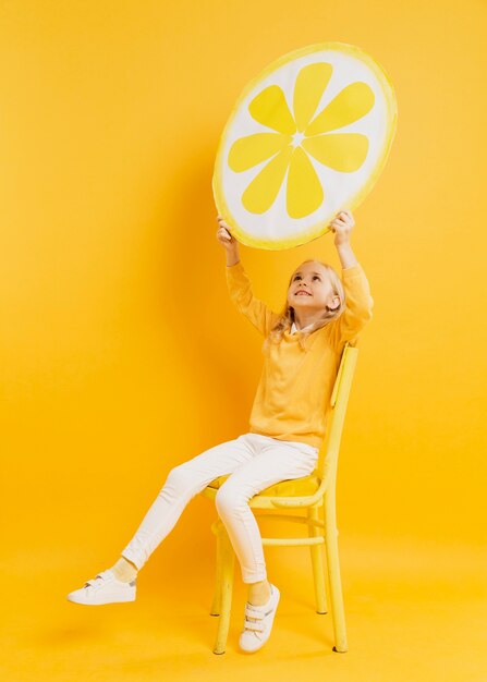 Girl posing while holding up lemon slice decoration
