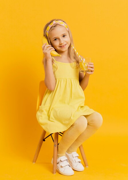 Free photo girl posing with a banana as a telephone