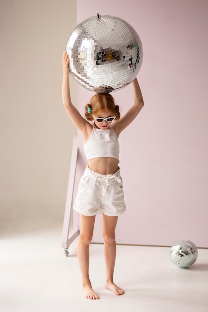 Girl posing with disco ball full shot