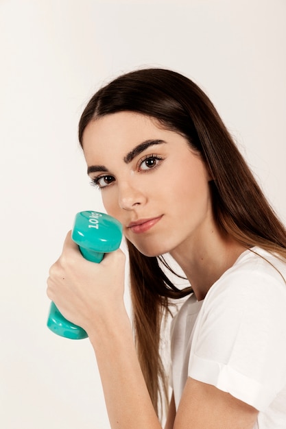 Free photo girl posing with dumbbells