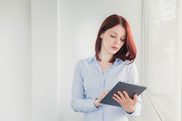 Girl posing with tablet in office