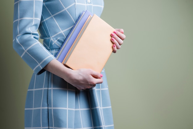 Ragazza che propone con due libri