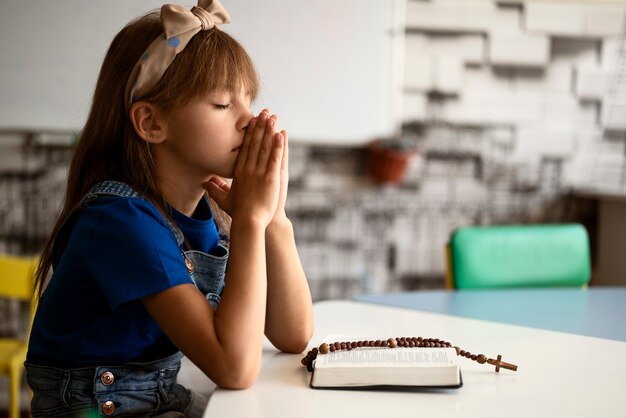 girl praying at sunday school side view