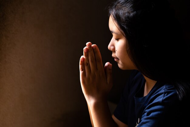 girl praying with her eyes closed
