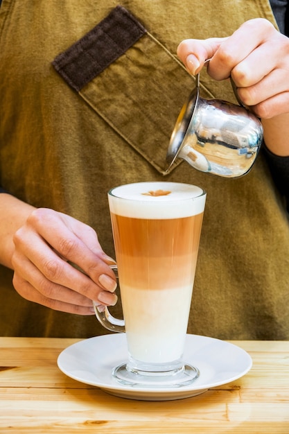 Girl preparing glass of coffee