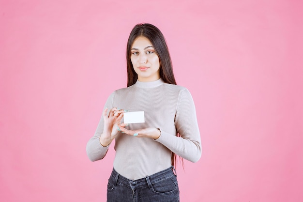 Girl presenting her business card to a business partner