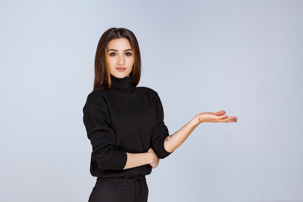 Girl presenting something at her open hand. High quality photo