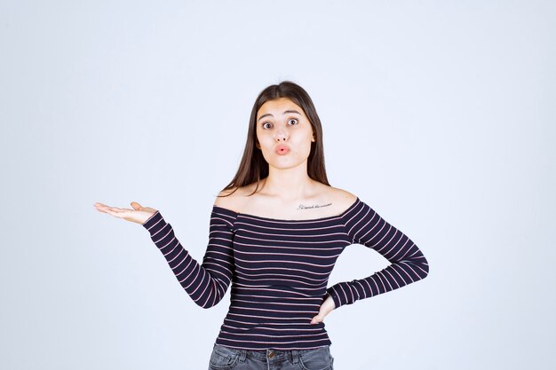 Girl presenting something in her open hand. 