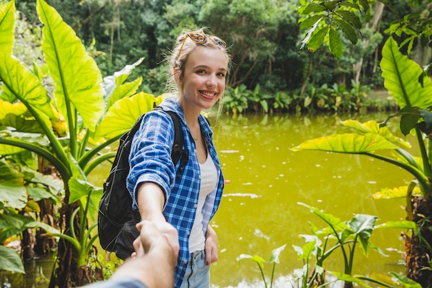 Free photo girl pulling boyfriend into jungle