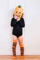 Free photo girl in pumpkin mask