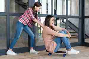 Free photo girl pushing mom on skateboard