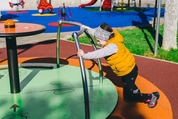 Girl pushing roundabout in park