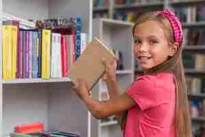 Free photo girl putting back a book on the shelf