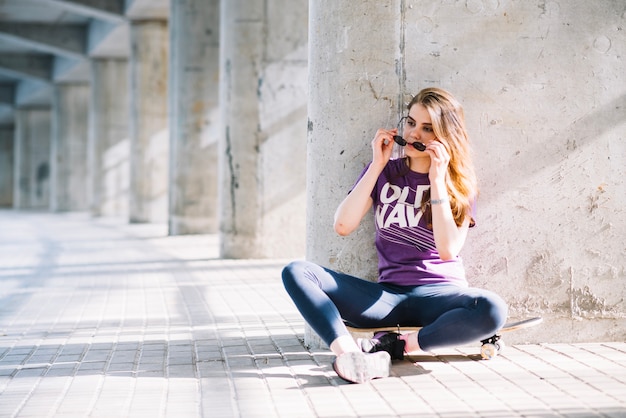 Foto gratuita ragazza che mette gli occhiali da sole