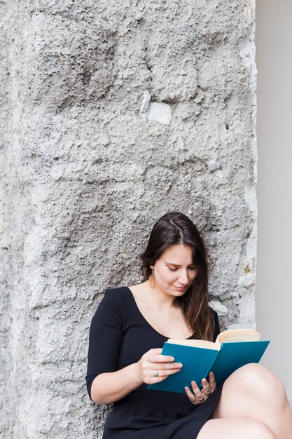 Girl reading a book in the street